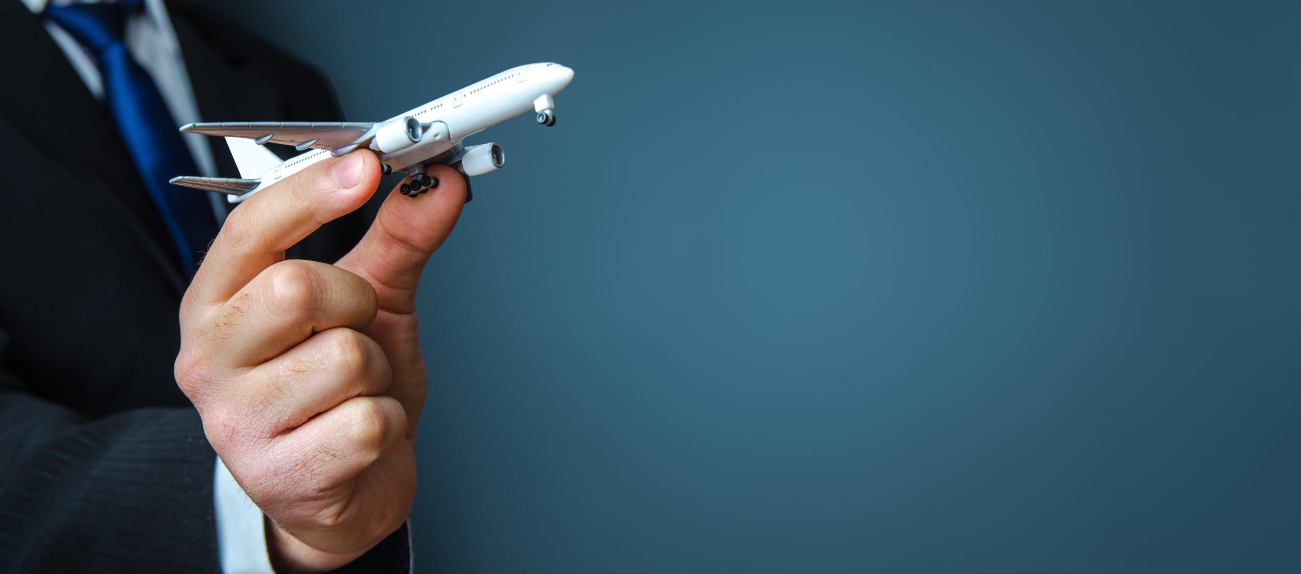 Businessman holding a airplane. Organization of flight traffic. Business and transport, air communication. Infrastructure for business development. Airline loyalty program. Tourism and travel.